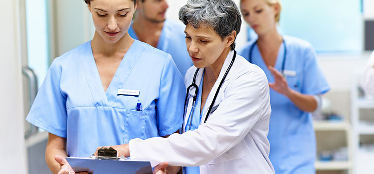 advanced practice nurse practitioner confers with nurses doing clinicals