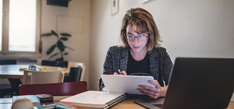 woman student works on tablet while she studies