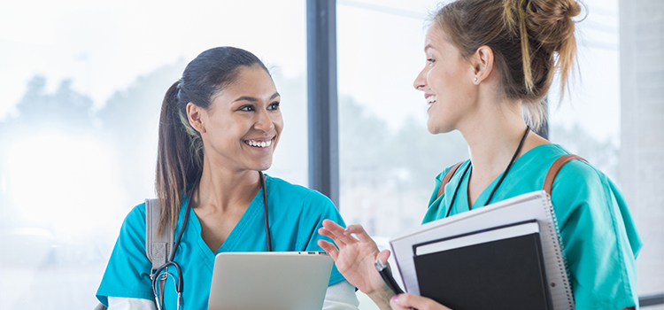 two female nurses talking animatedly