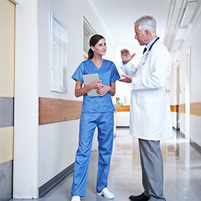 nurse and doctor talking in hospital hallway