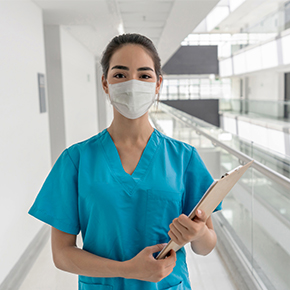masked female nurse holding clipboard