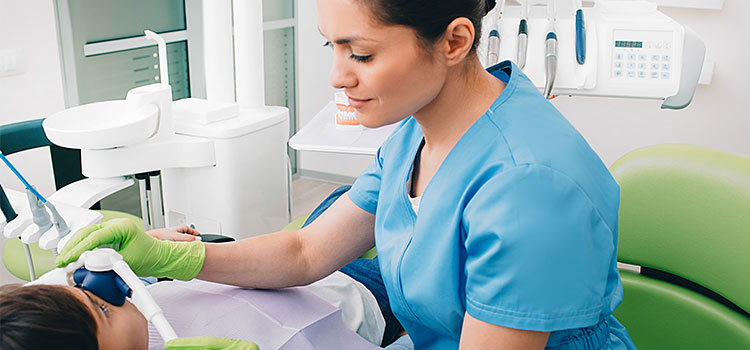 dental anesthetist helping youth patient adjust nosepiece