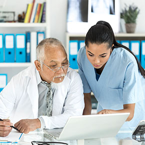 woman confers with doctor on paperwork
