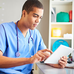 male nurse practitioner uses electronic notepad at desk