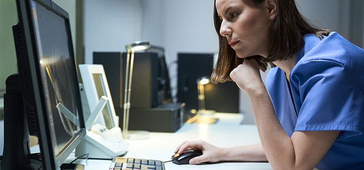 intense woman nurse working on desktop
