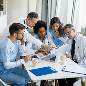 medical staff conversing over laptop in meeting
