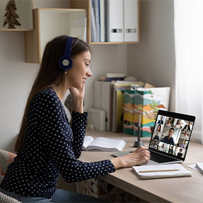 student at desk with laptop in video lecture