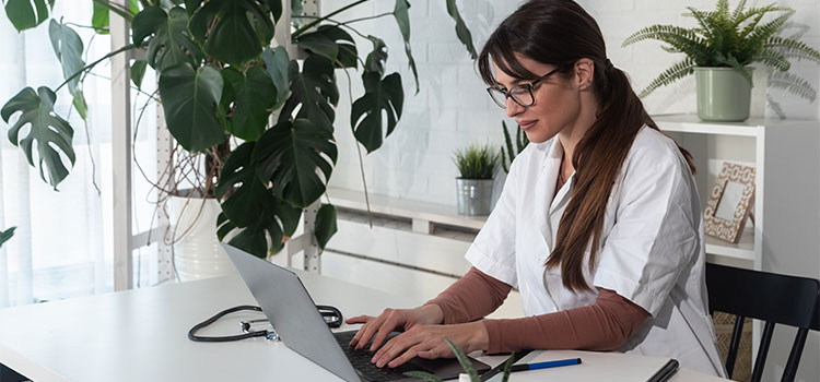 dermatology nurse doing research on laptop computer