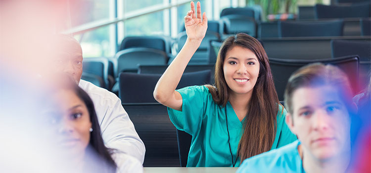 nursing student raising her hand in classroom