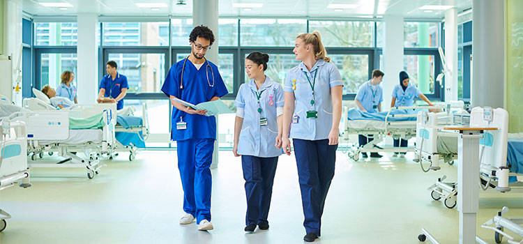 three nurses walking together in medical facility