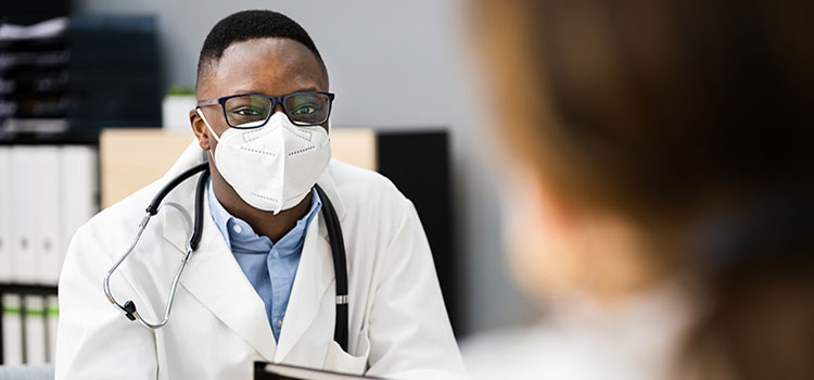 male nurse works at desk with another nurse