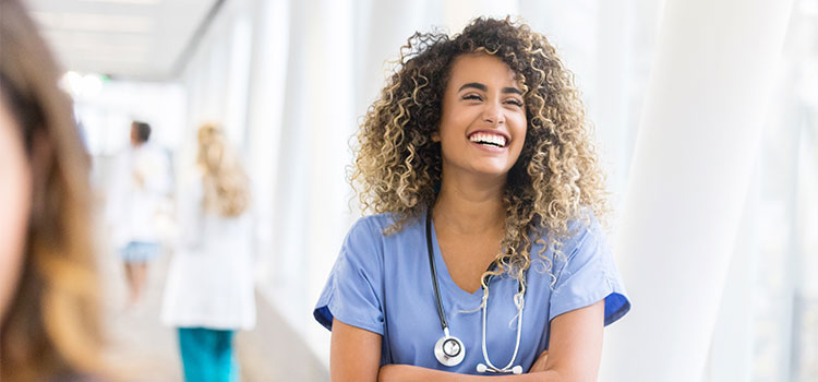 A nurse in a hospital smiles.