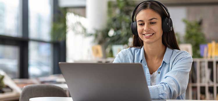 woman wearing headphones looking at laptop