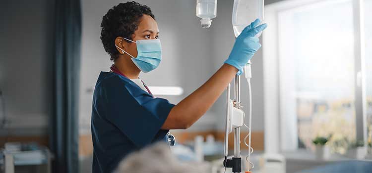 nurse starting IV drip for patient