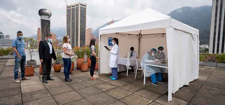 nurse checking in patients for immunizations at outside tent