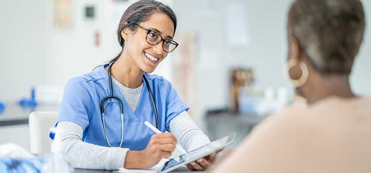 woman writing prescription for older female patient