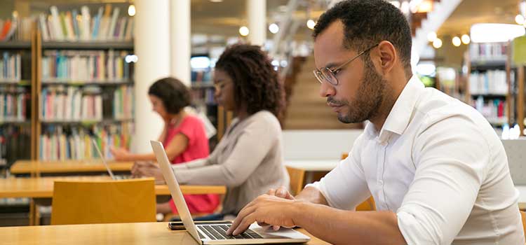man working on laptop in library