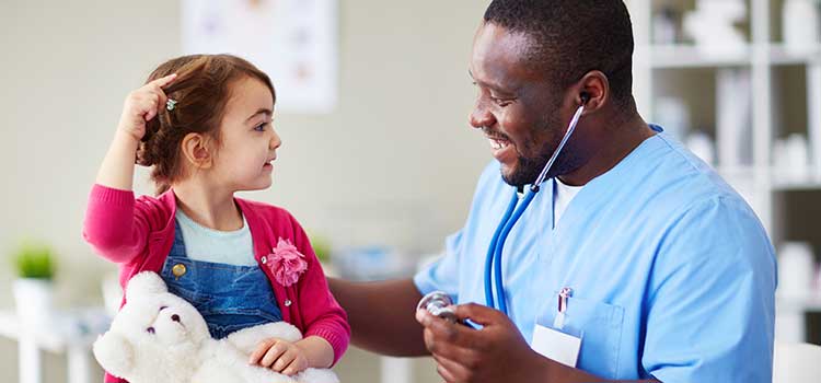 man using stethoscope on young child patient