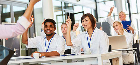 nursing students raise hands in class