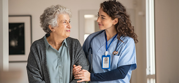 nurse walks with senior patient