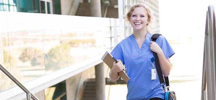 smiling nurse walking on college campus