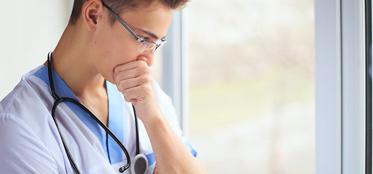 nurse looking out window contemplatively