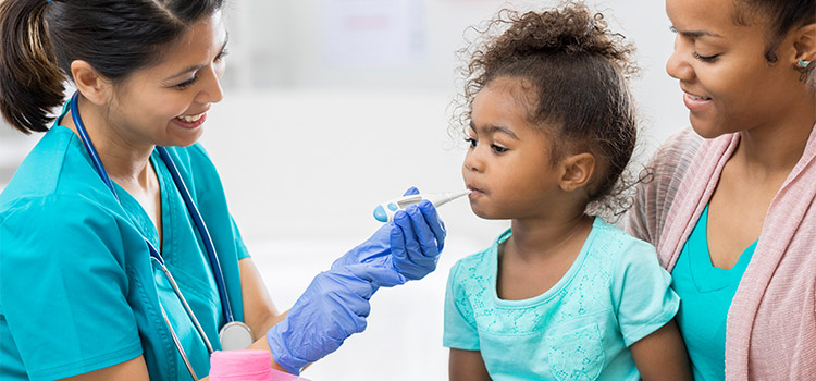 nurse takes child patient temperature