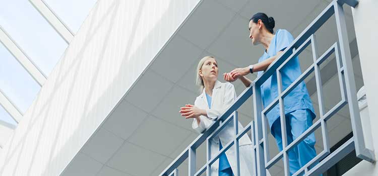 two nurses in serious discussion on balcomy