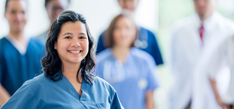 smiling nurse in front of medical team
