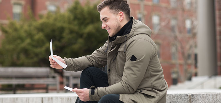 college student looking at acceptance letter to college