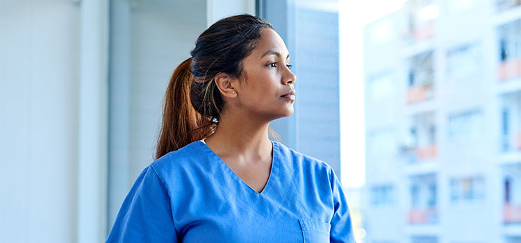 nurse looking out window at medical facility