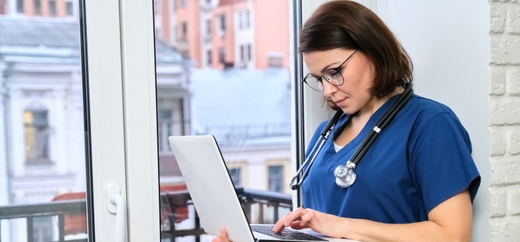nurse browsing on her laptop and applying for her nursing license