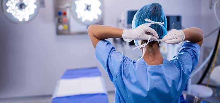 nurse tying cap in surgery