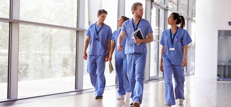 group of nurses talking and walking down the hallway