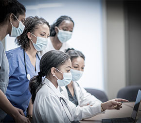 nurses working together looking at laptop computer