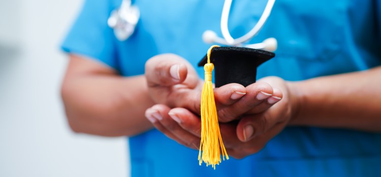nurse holding small graduation cap