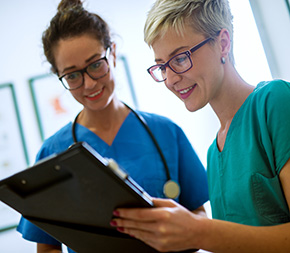 two nurses confer on patient vitals