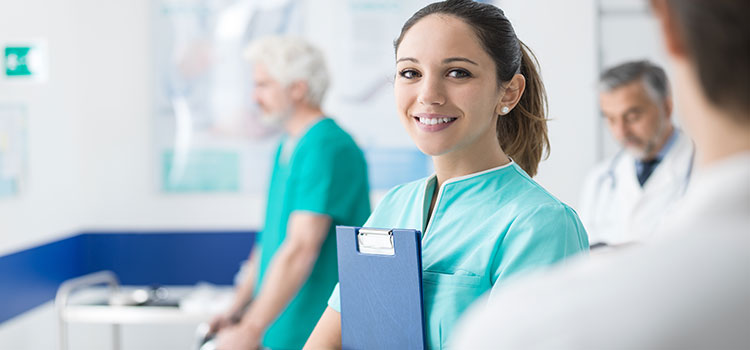 smiling nurse holding folder in nurse station