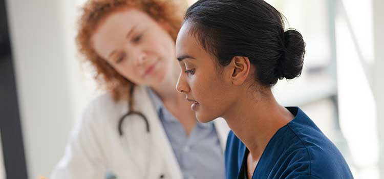 nurse student confers with doctor
