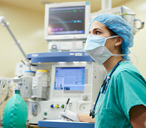 nurse in mask monitors patient vitals