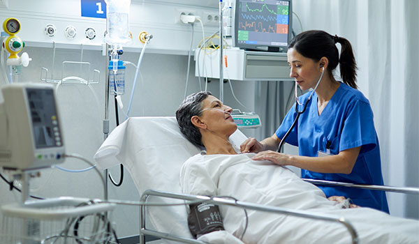 icu nurse listening to patient heartbeat