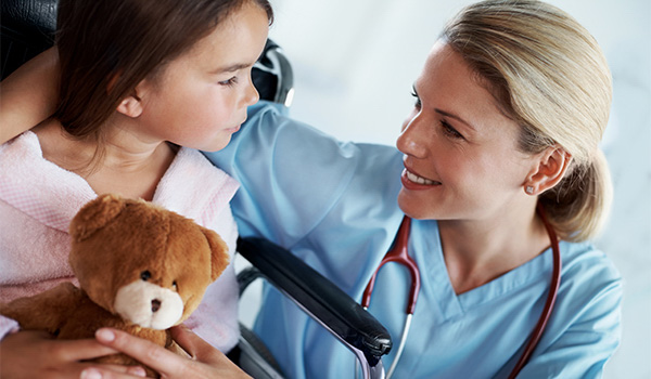 pediatric nurse with small child holding teddy bear