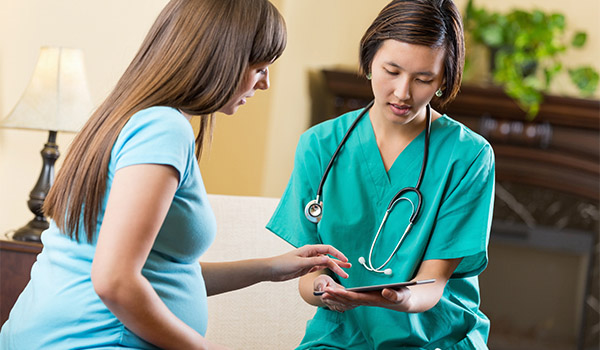 perinatal nurse verifies information with female patient