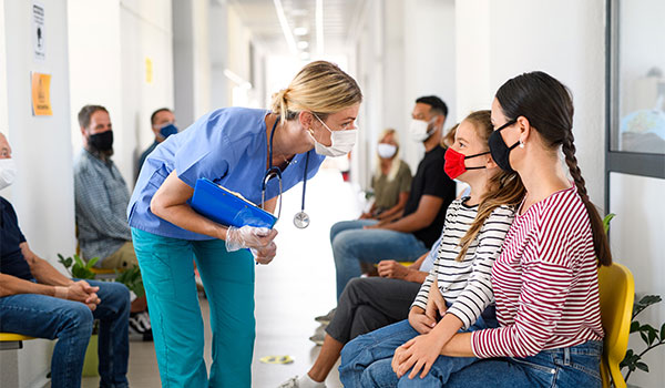 public health nurse talks with patients in hallway