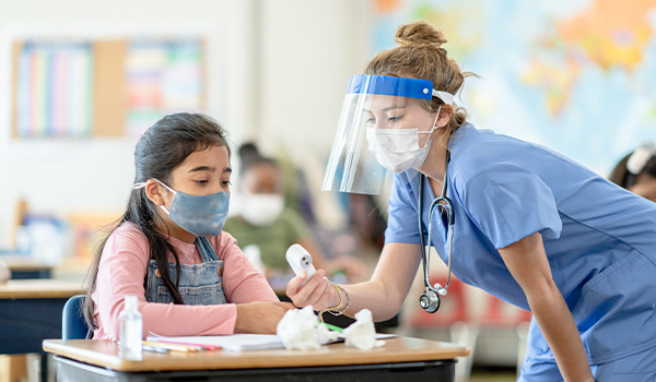 school nurse checks girl students temperature