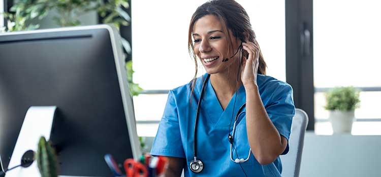 telehealth nurse confers with patient on computer with headset