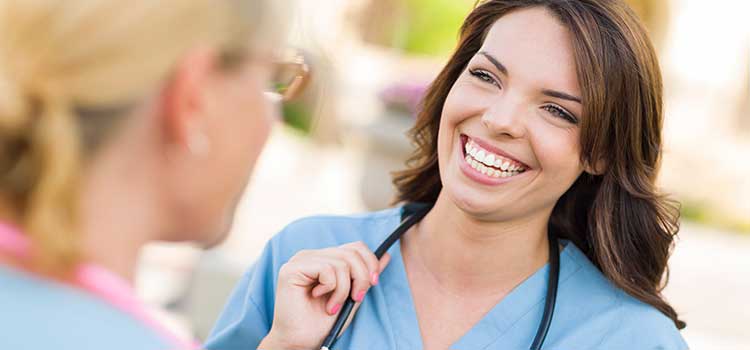 smiling nurse graduate talks to another nurse