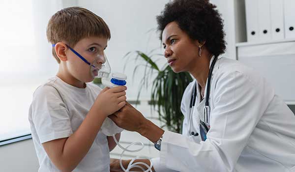 respiratory nurse works with young patient