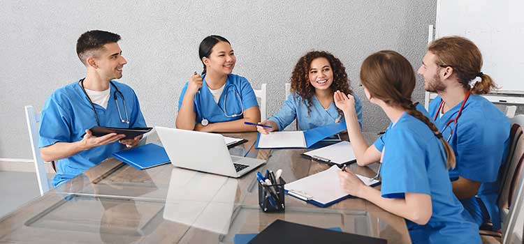 team of nurses work over laptop and brainstorm