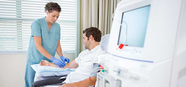dialysis nurse administers dialysis treatment to a patient